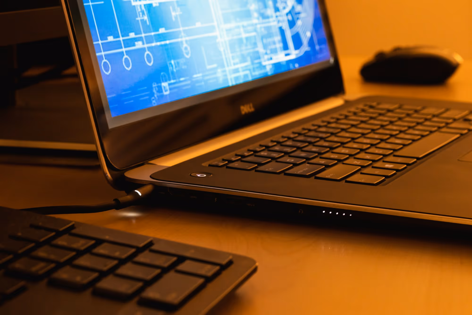 Laptop displaying a technical drawing at an engineering workspace